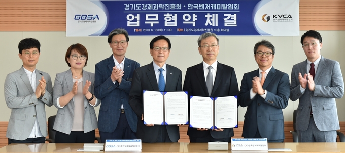 왼쪽에서 4번째 김기준 경과원장과 정성인 한국벤처캐피탈협회장이 협약서를 들고 양 기관 관계자들과 함께 기념촬영을 하고있다.