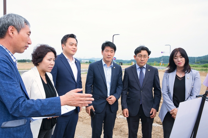 시립새솔하나어린이집 건립부지를 방문한 기획행정위원회 위원들이 관련부서의 설명을 청취하고 있다.