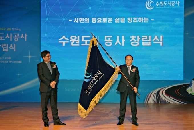 2018년 2월 장안구민회관 한누리아트홀에서 열린 수원도시공사 창립식에서 초대사장인 이부영 사장이 공사기를 흔들고 있다.