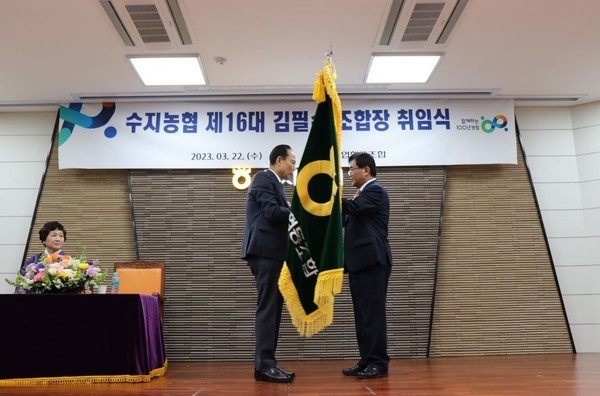 22일 개최된 제16대 수지농협 조합장 취임식에서 김필수(좌) 16대 조합장이 홍순용(우) 15대 조합장으로 부터 농협 깃발을 전달받고 있다.