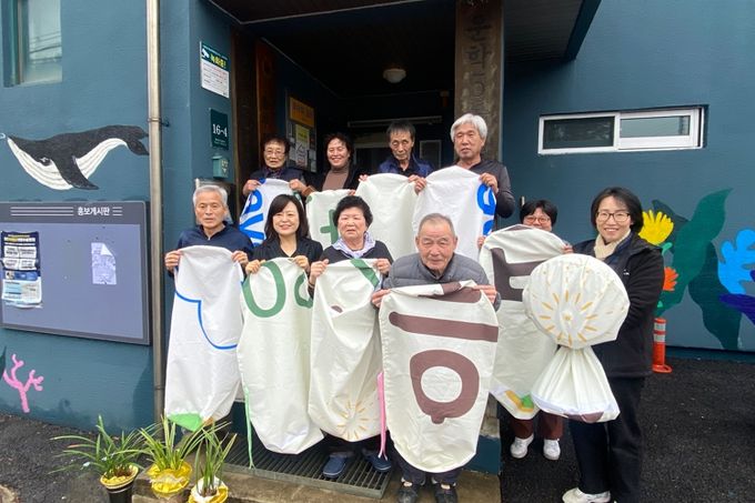 기후변화체험교육센터 강사들이 지난 19일 현수막 재활용 선풍기 커버를 삼삼경로당에 전달했다.