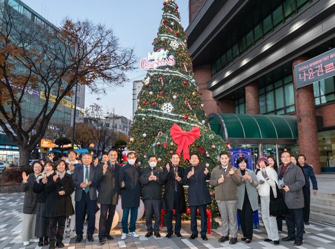 박승원 광명시장이 지난 28일 광명시민회관 앞 광장에서 열린 ‘2025년 송년 희망트리 점등식’에 참석해 기념사진을 촬영하고 있다.