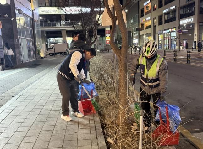 이현재 하남시장이 지난 21일 저녁 미사문화거리에서 시 소속 환경공무관들과 함께 빗자루를 들고 야간 청소 정화 활동을 펼치고 있다.