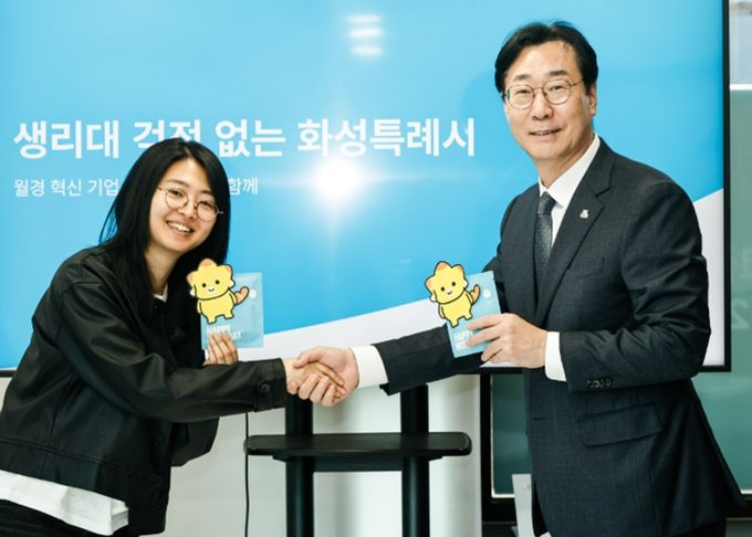 정명근 화성특례시장이 김도진 (주)해피문데이 대표와 함께 (가칭) 코리요 생리대 시제품을 들고 포즈를 취하고 있다.