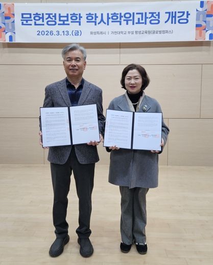 윤미영 도서관정책과장과 가천대 평생교육원 이재원 주임교수가 협약서를 들고 기념촬영을 하고 있다