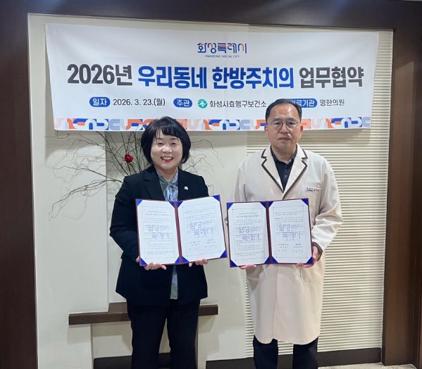 유종우 효행구보건소장과 명한의원 윤탁현 원장이 업무협약을 체결하고 협약서를 들고 기념촬영을 하고 있다